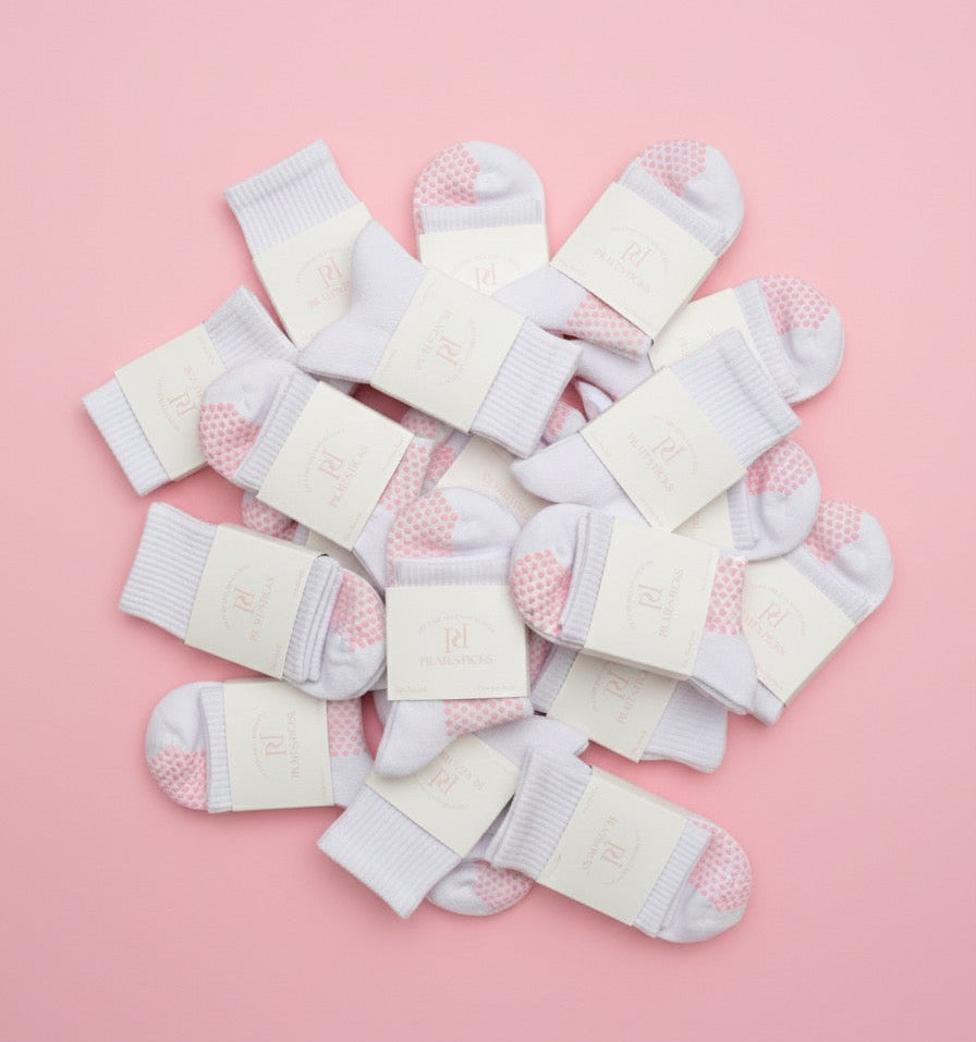 Multiple pairs of baby socks on a pink background
